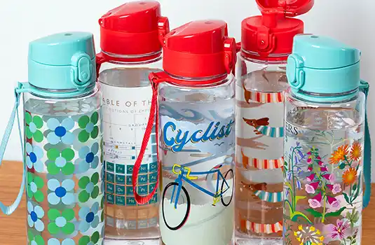 Five reusable water bottles with colourful patterns, red and blue lids, displayed on a white background.