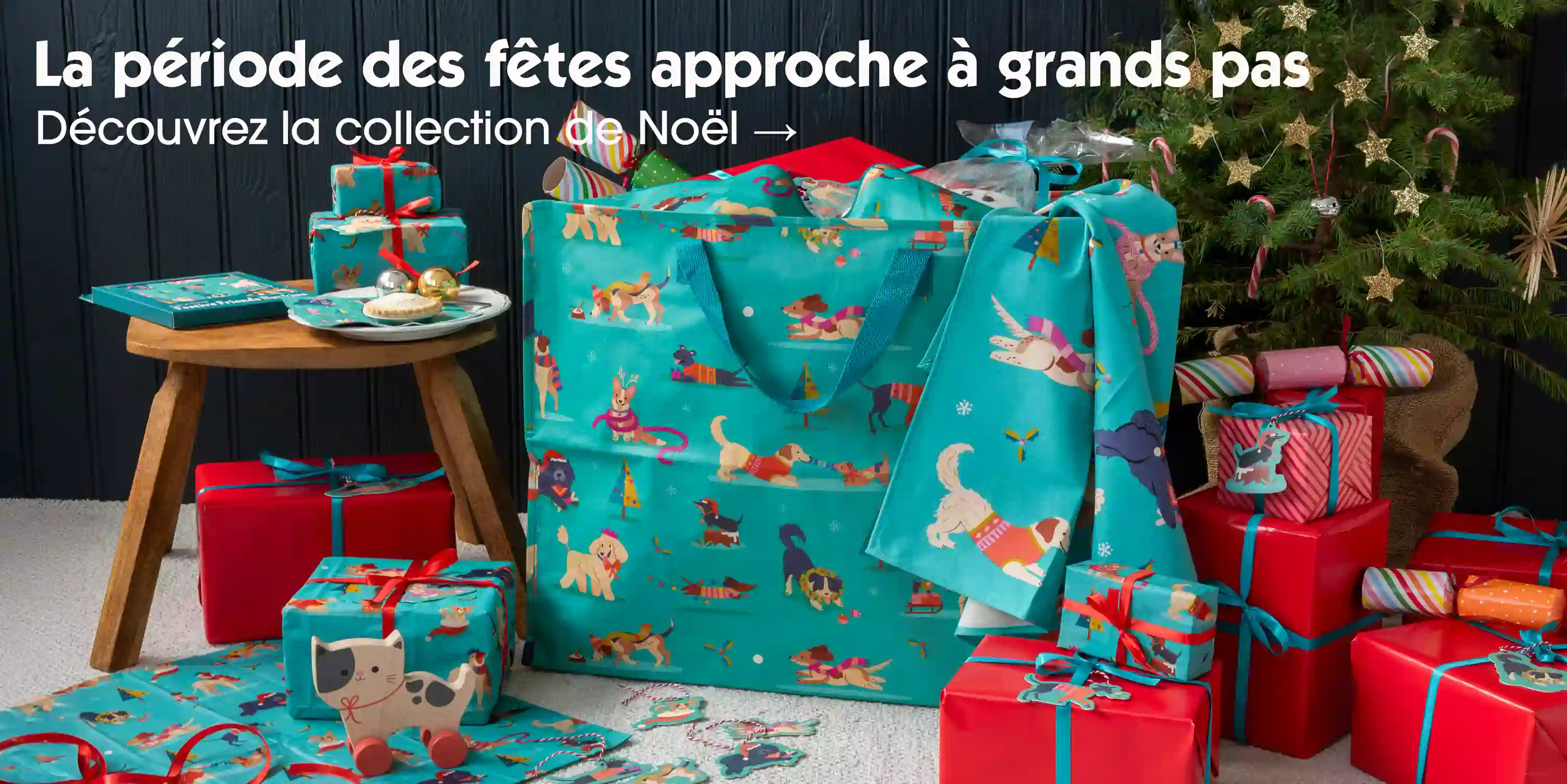 Festive-themed gift scene with dog-patterned teal bags, wrapped presents, and festive decorations.