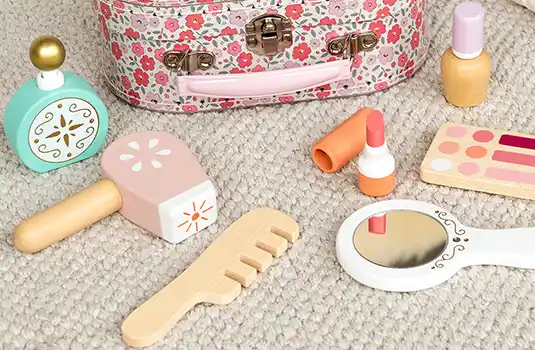 Toy makeup and accessories set with a floral suitcase, including wooden lipstick, perfume, and mirror.