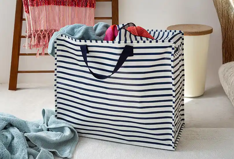 A jumbo storage bag, featuring horizontal navy blue stripes on a white background, evoking a coastal, seafaring aesthetic.
