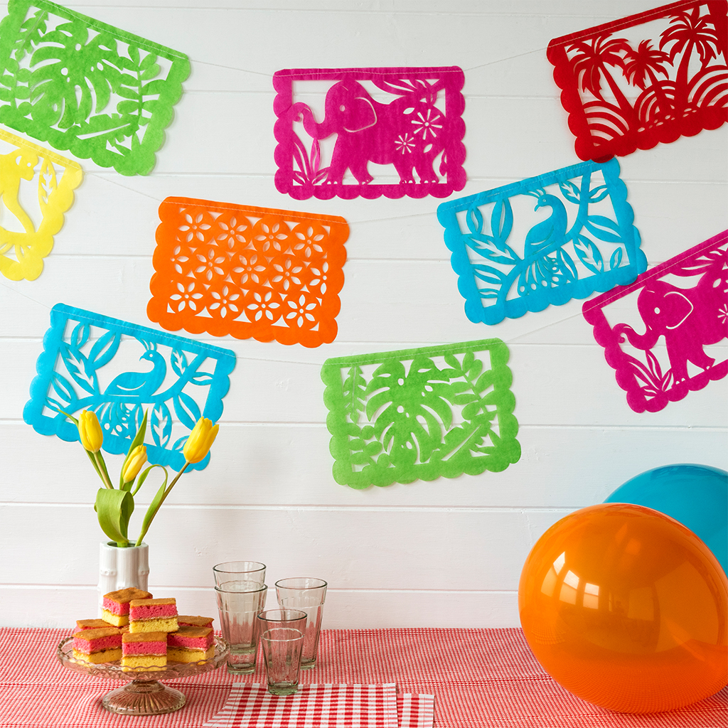 Colorful paper bunting with intricate cut-out designs, including elephants, birds, and floral patterns. The bunting features rectangles in green, pink, red, orange, and blue.