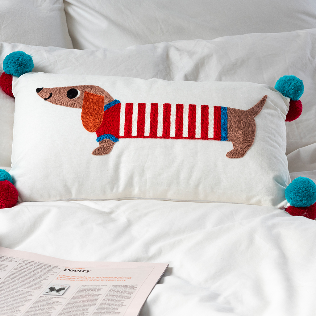 embroidered cushion with pom poms - sausage dog