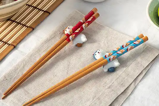 Charming noodle set featuring adorable dog-shaped chopstick rests and pairs of Japanese-style wooden chopsticks.