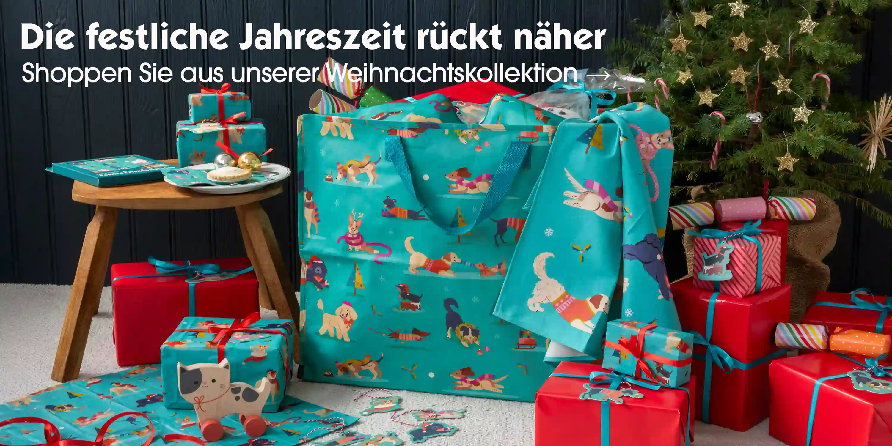Festive-themed gift scene with dog-patterned teal bags, wrapped presents, and festive decorations.